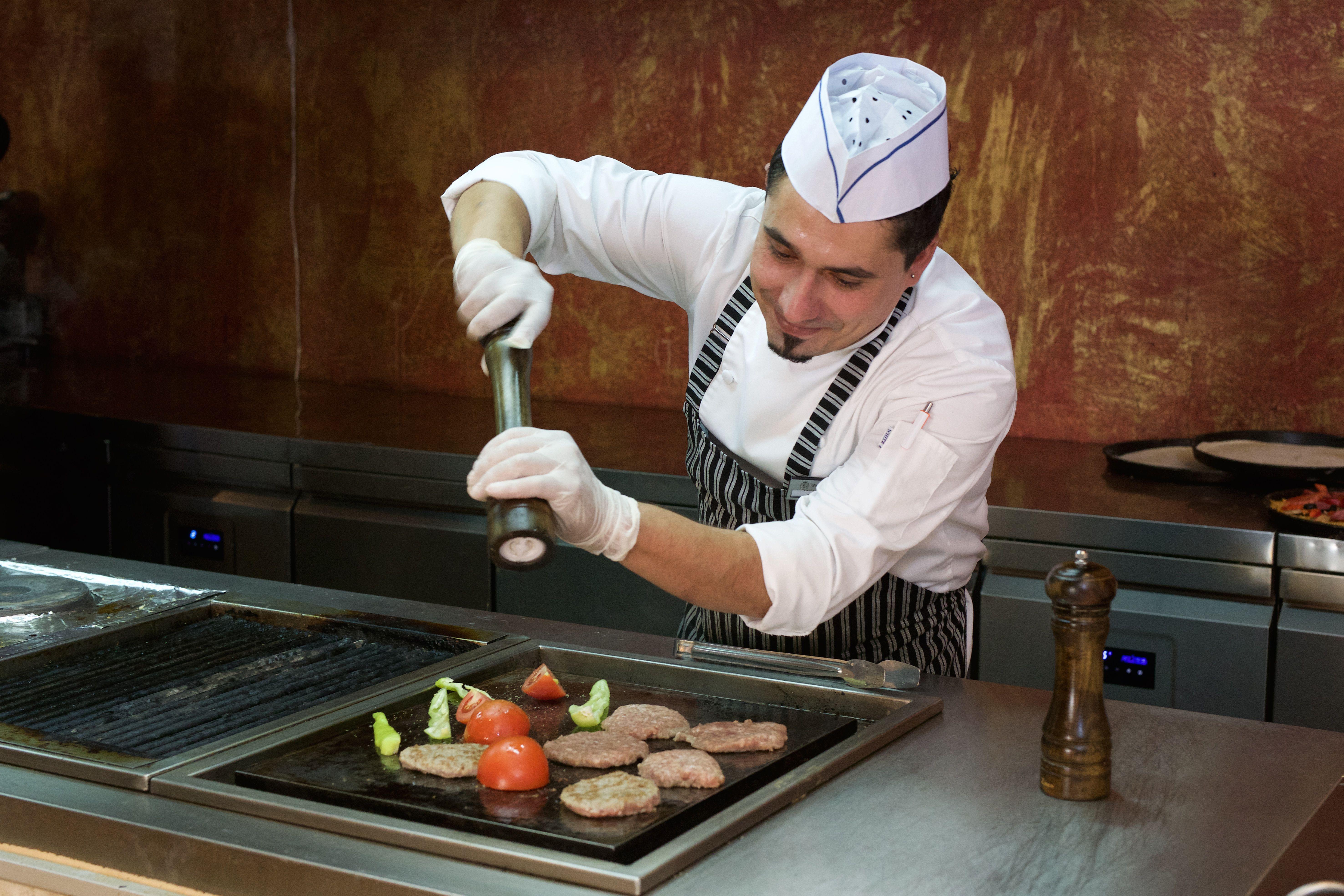 Imperial Palace Hotel Σάνι Μπιτς Εξωτερικό φωτογραφία A sous-chef seasoning food