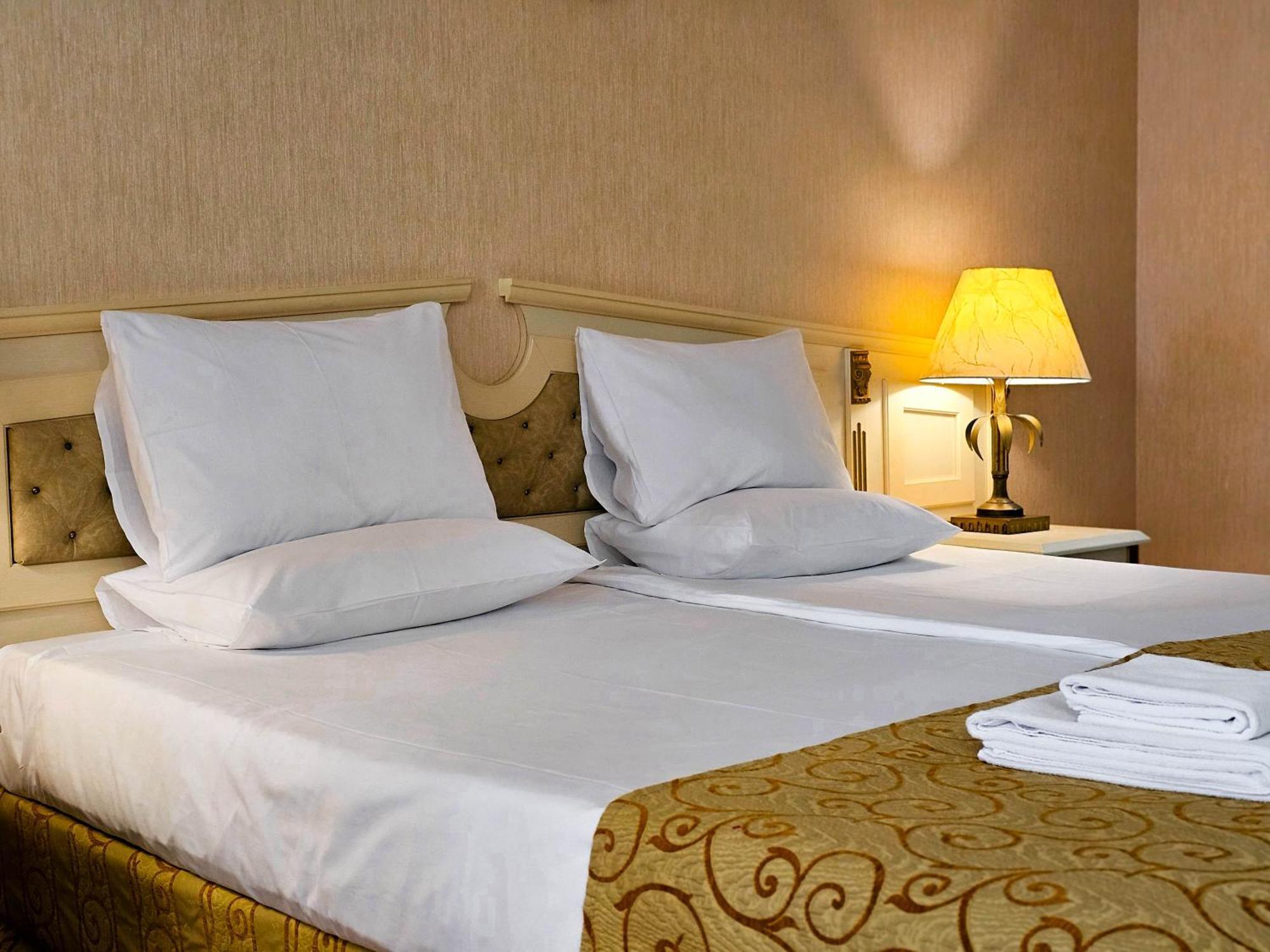 Imperial Palace Hotel Σάνι Μπιτς Εξωτερικό φωτογραφία A bed with pillows and a lamp